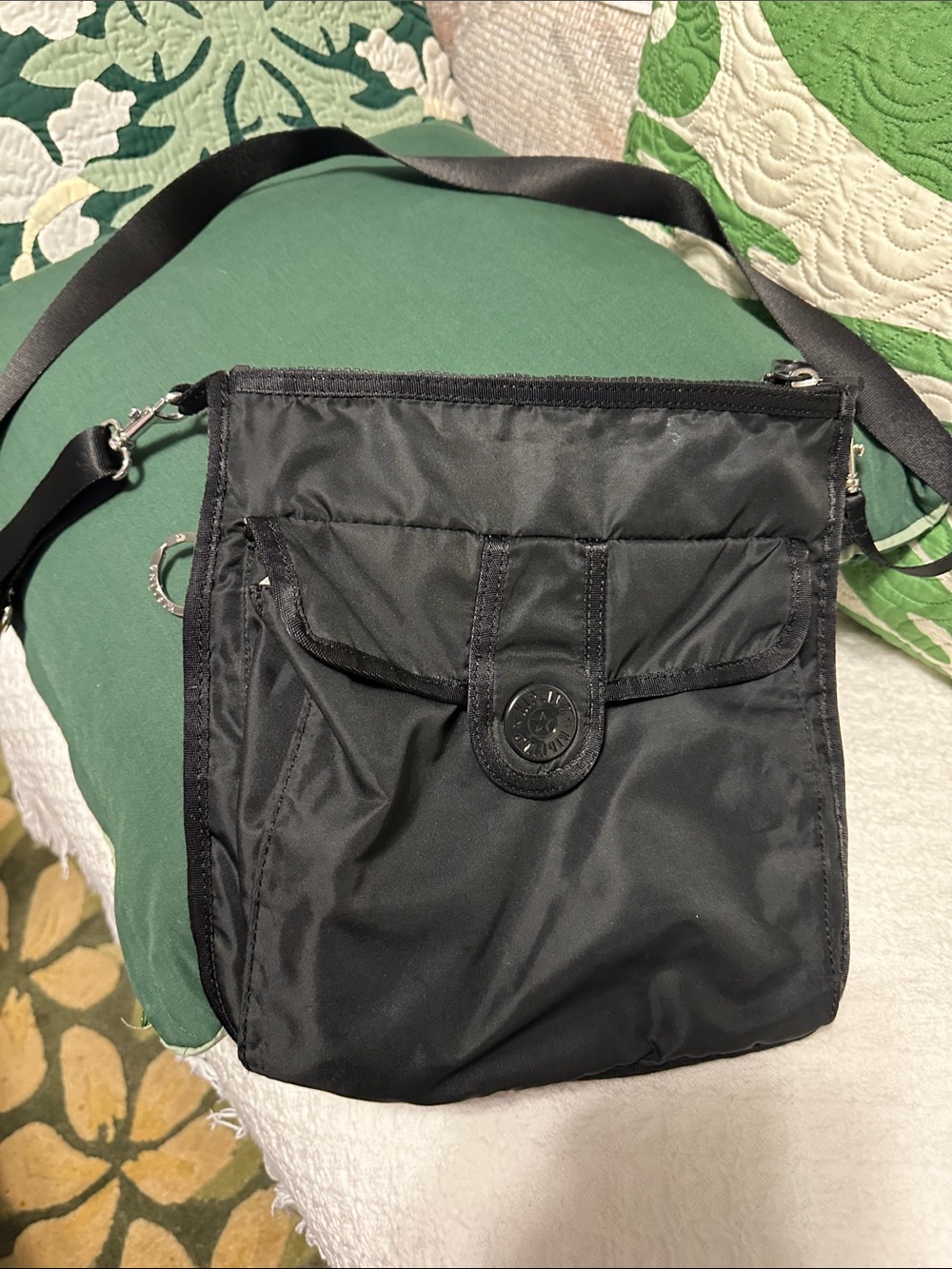 Black Kipling nylon crossbody with adjustable shoulder strap & front snap pocket